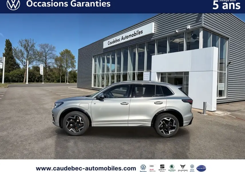 Volkswagen Tiguan eHybrid argent Dolomite vu de profil côté gauche, avec jantes noires et toit ouvrant panoramique.