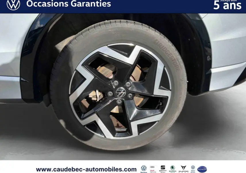Gros plan sur la roue avant droite du Volkswagen Tiguan 2025 argent Dolomite avec jante alliage noir et argentée.
