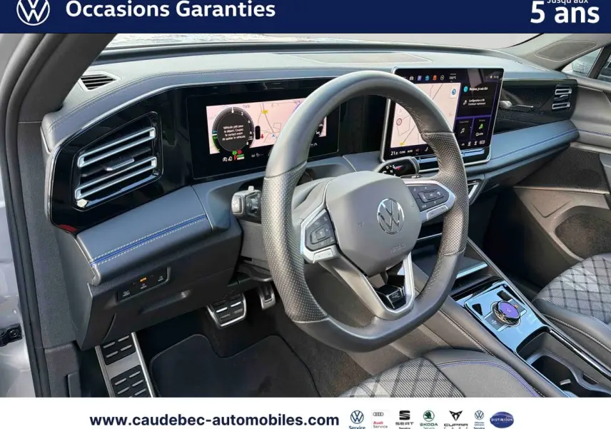 Intérieur avant droit du Volkswagen Tiguan eHybrid 2025 argent Dolomite, volant sport et écran tactile large visible.