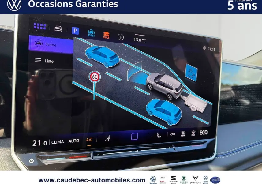 Écran tactile intérieur montrant l'assistant de conduite avec représentation du Volkswagen Tiguan argent Dolomite et remorque.