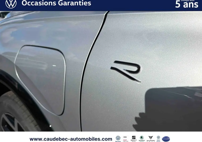 Détail de la trappe de recharge côté gauche d’un Volkswagen Tiguan eHybrid 2025 en argent Dolomite avec badge R.