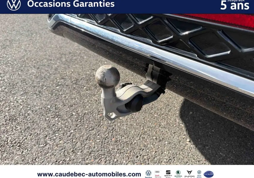 Gros plan sur le crochet d'attelage escamotable à l'arrière d'un Volkswagen Tiguan argent Dolomite.
