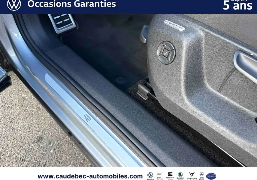 Détail de la porte côté conducteur du Volkswagen Tiguan eHybrid argent Dolomite avec seuil de porte ErgoActive visible.
