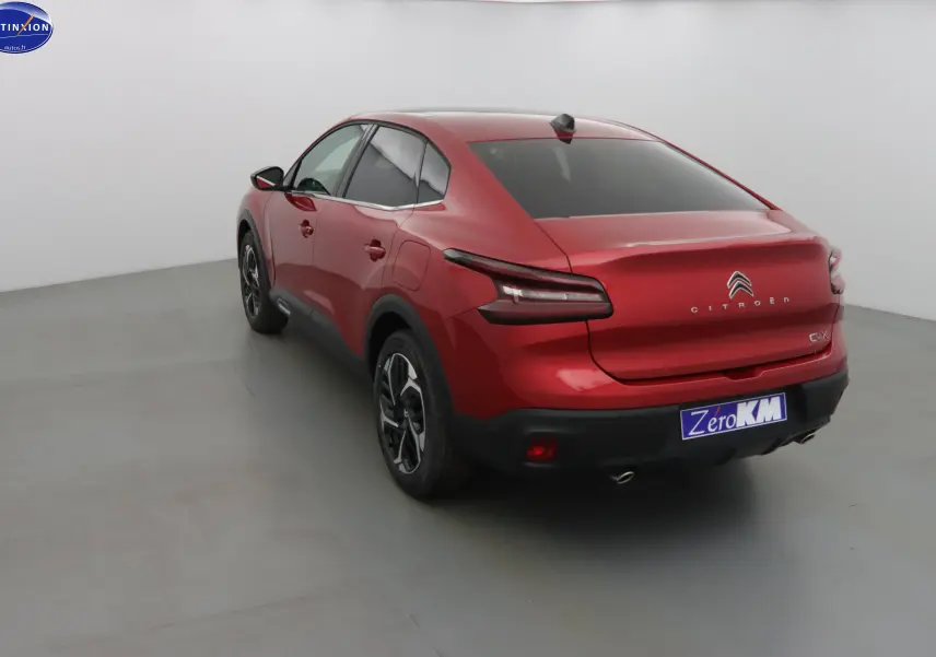 Citroën C4 X rouge Elixir métal vue 3/4 arrière droit, avec feux LED et jantes noires bicolores.