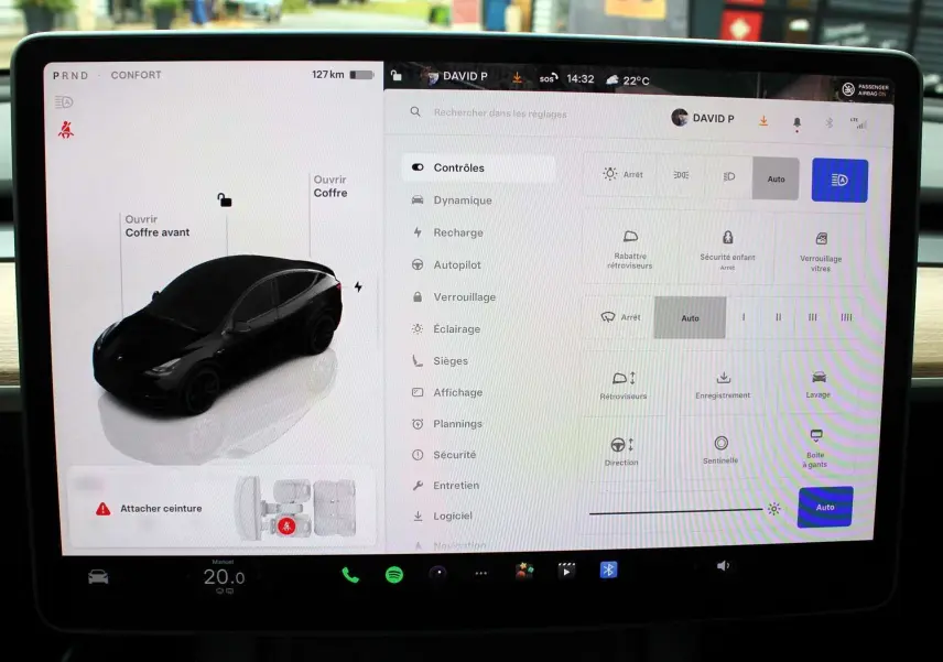 Écran tactile intérieur de la Tesla Model Y 2024 montrant le menu de contrôle et une vue 3D noire du véhicule en profil côté gauche.