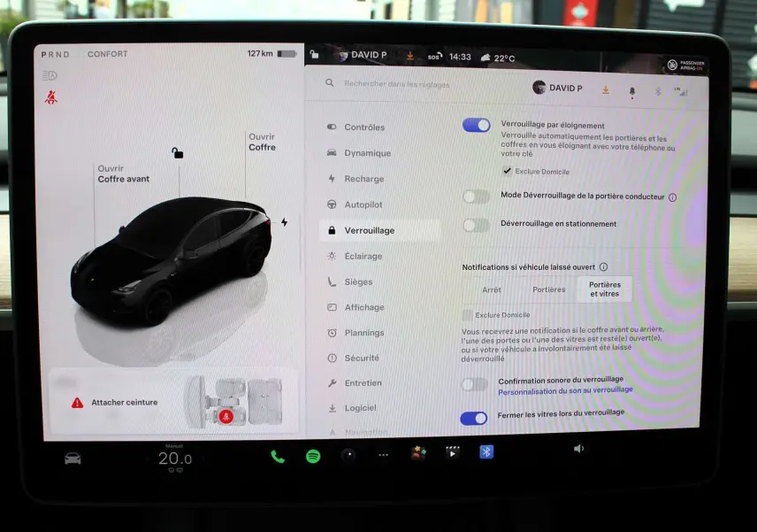 Écran tactile intérieur affichant les réglages de verrouillage d'une Tesla Model Y noire métal, vue de face du tableau de bord.