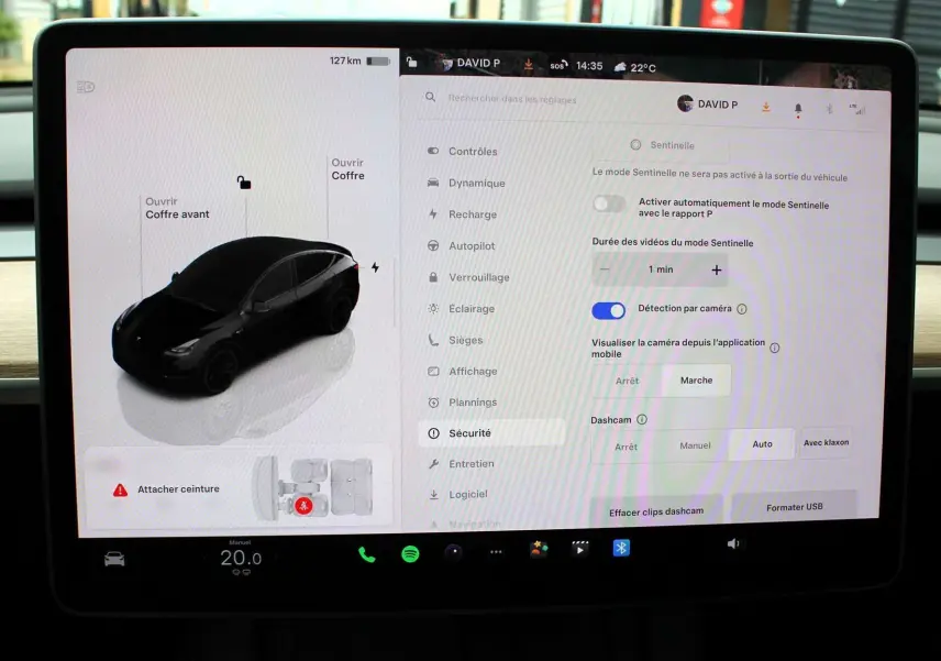 Écran tactile intérieur de Tesla Model Y noir métal 2024 montrant les réglages de sécurité et l'interface du véhicule.