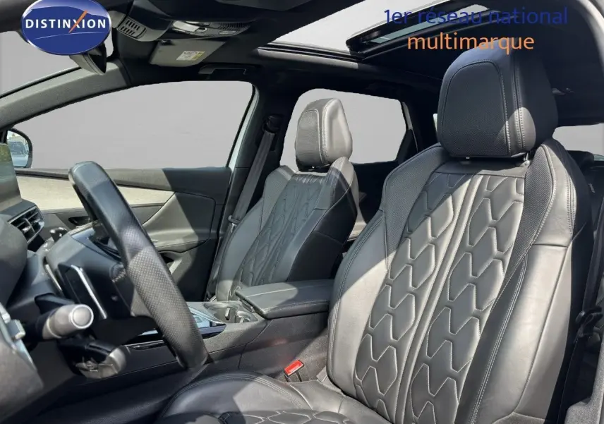Intérieur du Peugeot 3008 GT 2018 montrant les sièges avant en cuir noir avec surpiqûres et toit ouvrant panoramique.