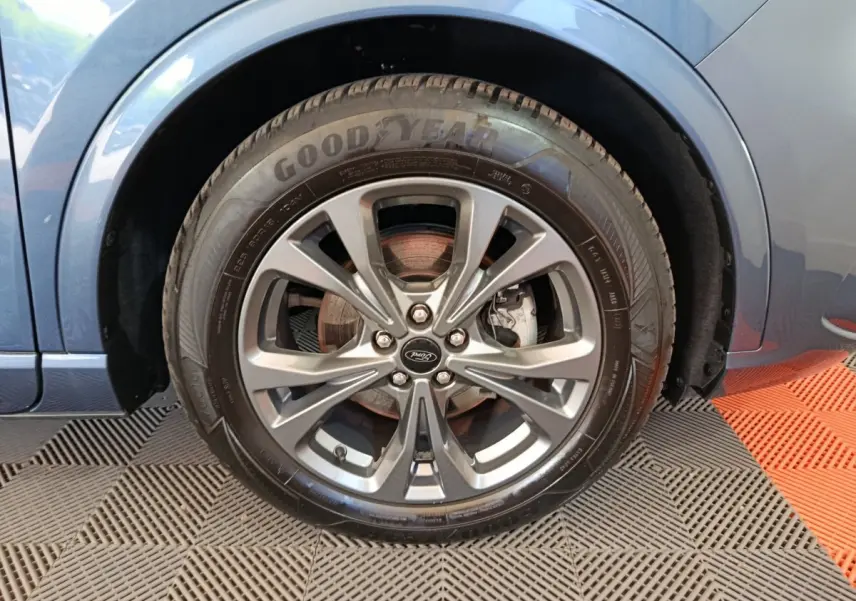 Gros plan sur la roue avant gauche du Ford Kuga bleu 2024 avec jante alliage et pneu Goodyear visible.