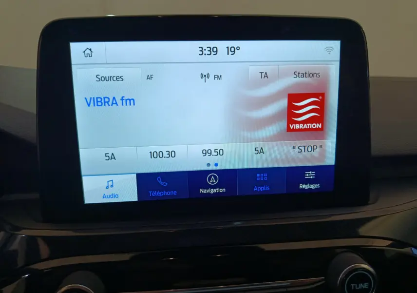 Écran tactile central du tableau de bord du Ford Kuga 2024 affichant la radio VIBRA fm en mode audio.