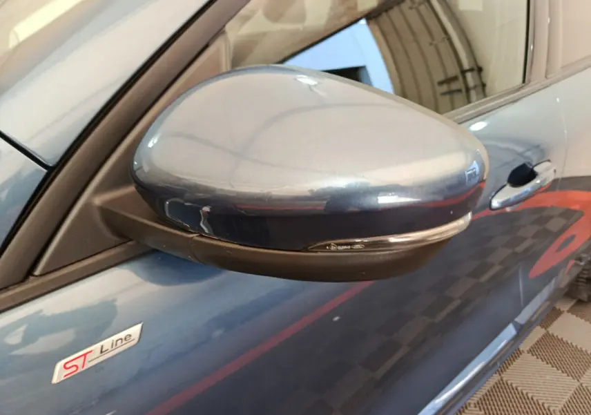 Rétroviseur côté gauche bleu métallisé du Ford Kuga 2024 ST Line avec logo ST Line sur la portière.