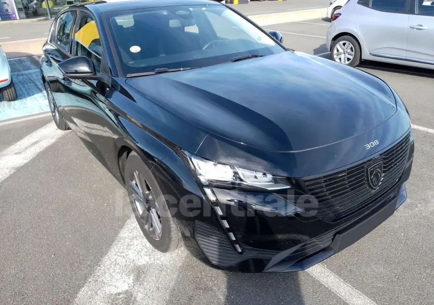 Peugeot 308 noire vue en 3/4 avant droit, mettant en valeur sa calandre moderne et ses phares LED distinctifs.