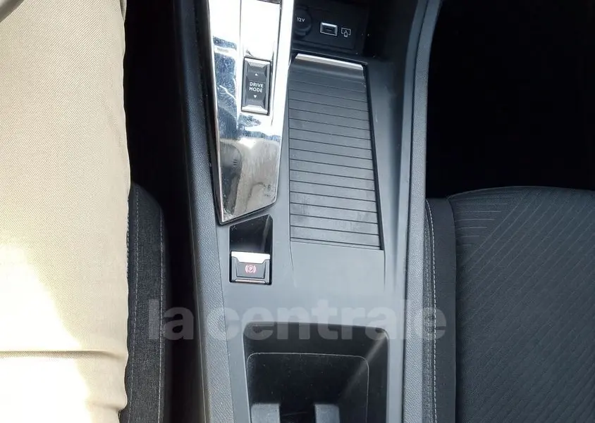 Vue plongeante sur la console centrale noire de la Peugeot 308 2022, montrant levier de vitesses automatique et commandes intégrées.