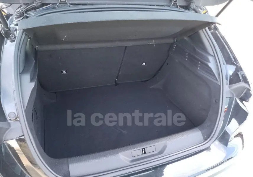 Coffre ouvert d'une Peugeot 308 noire, vue arrière montrant l'espace de chargement vide et la garniture intérieure noire.