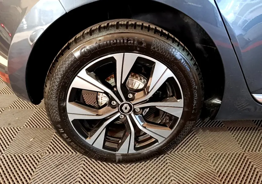 Gros plan sur la roue avant droite gris foncé de la Renault Clio Evolution SCe 65 avec jante alliage bicolore et logo Renault.