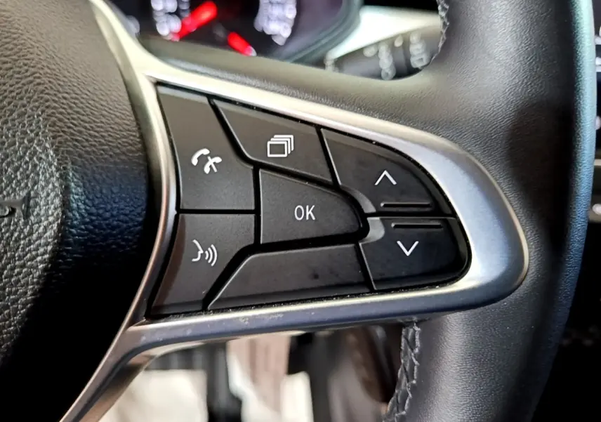 Gros plan sur les commandes multifonctions à droite du volant cuir noir de la Renault Clio gris foncé 2022.