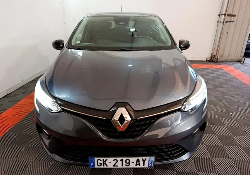Renault Clio Evolution SCe 65 gris foncé vue de face avec phares LED allumés dans un garage.