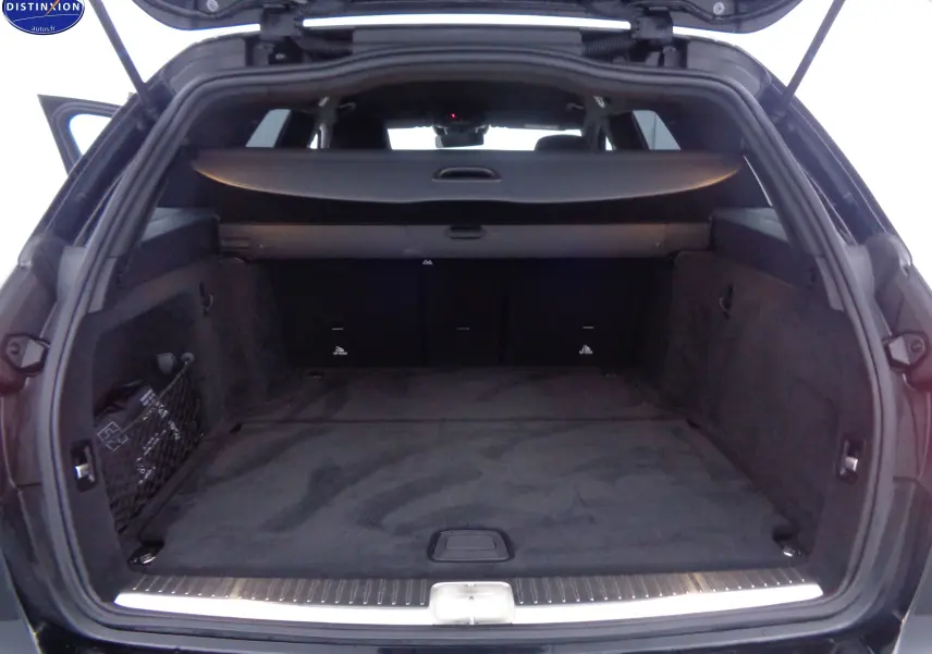 Coffre ouvert en vue arrière d'un Mercedes Classe C Break 220D noir métal, avec cache-bagages et intérieur spacieux.