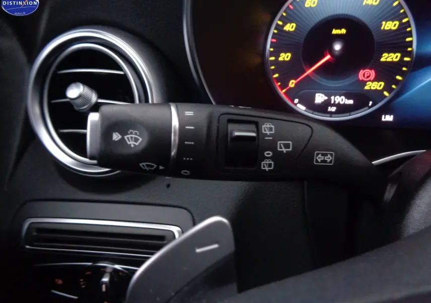 Gros plan sur la commande d’essuie-glace à gauche du volant dans l’habitacle noir du Mercedes Classe C Break 220D AMG Line.