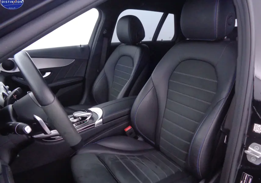 Intérieur noir cuir de la Mercedes Classe C Break 220D AMG Line, vue côté conducteur avec sièges avant et console centrale.