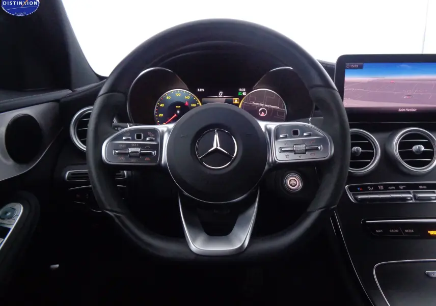 Vue centrée sur le volant cuir noir du Mercedes Classe C Break 220D avec tableau de bord digital et écran tactile.