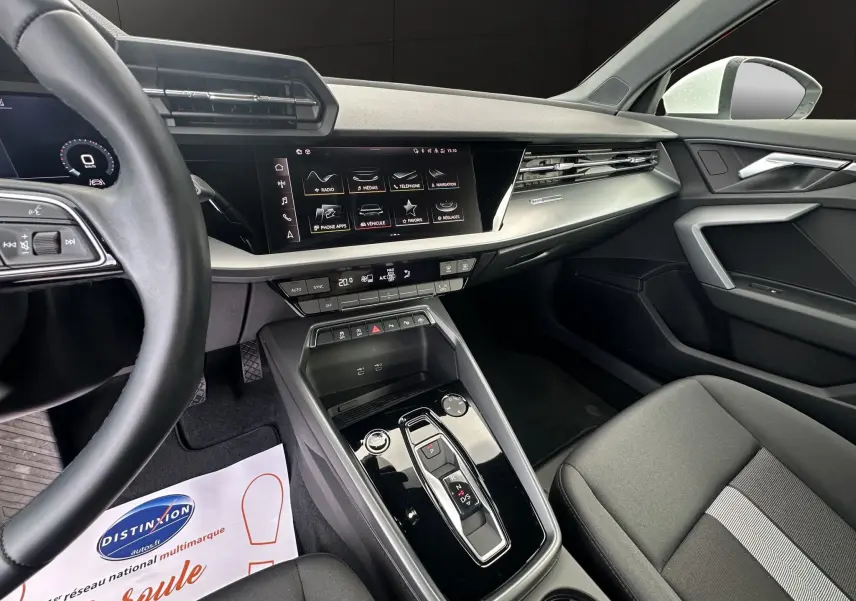 Intérieur noir de l'Audi A3 Sportback 2024, vue côté passager avec console centrale brillante et écran tactile.