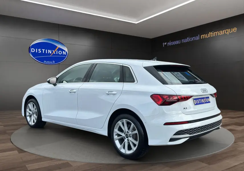 Audi A3 Sportback blanc Arkona vue 3/4 arrière droit, jantes alliage léger et feux LED distinctifs.