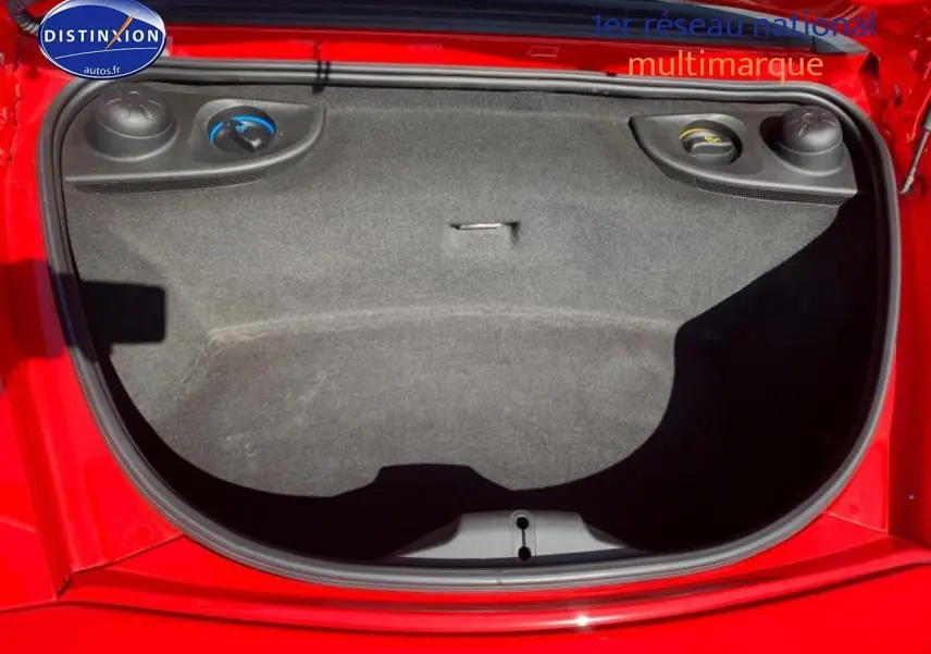 Vue plongeante sur le coffre avant rouge d'une Porsche Boxster 981, montrant son espace de rangement vide.
