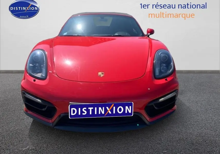 Vue frontale d'une Porsche Boxster rouge 2015 avec phares bi-xénon et boucliers couleur caisse.