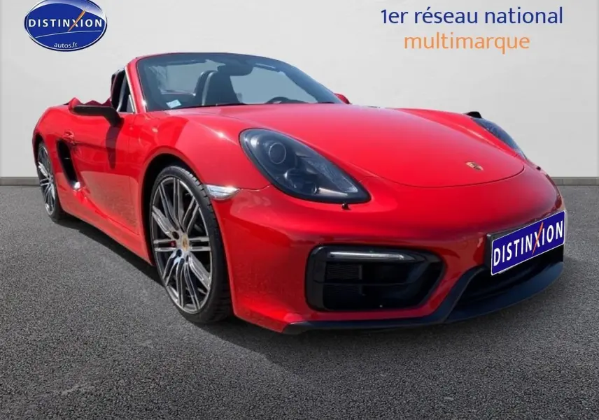 Vue 3/4 avant gauche d'une Porsche Boxster 981 rouge avec jantes alu et phares bi-xénon noirs.