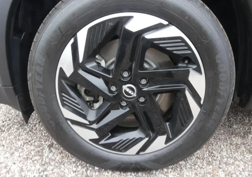 Gros plan sur la jante alliage bicolore noir et argent du Nissan Qashqai 1.5 e-Power gris métallisé.