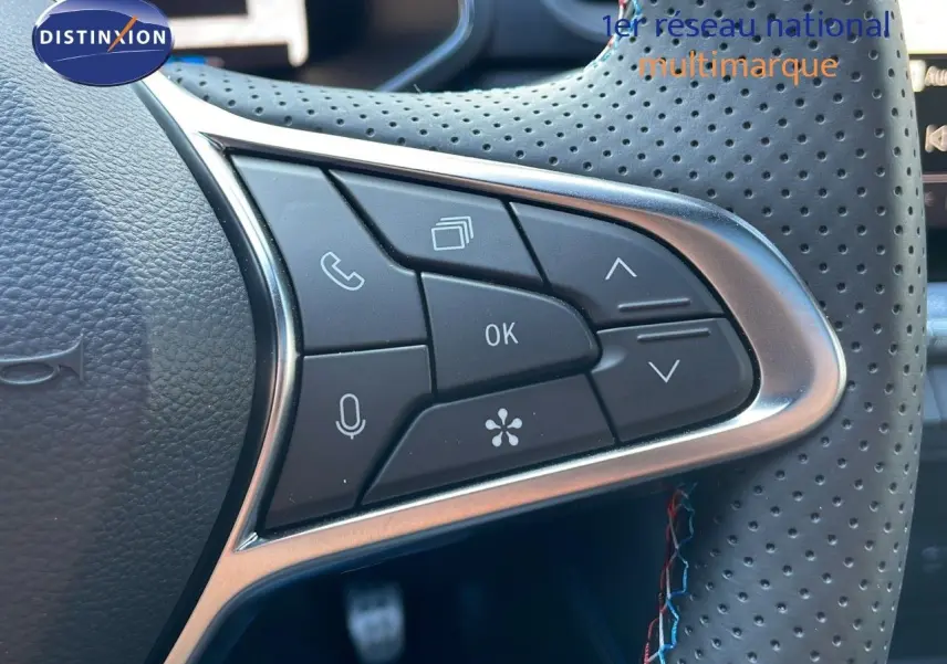 Gros plan sur les commandes au volant en cuir perforé du Renault Captur E-Tech hybride 2025, finition Esprit Alpine.