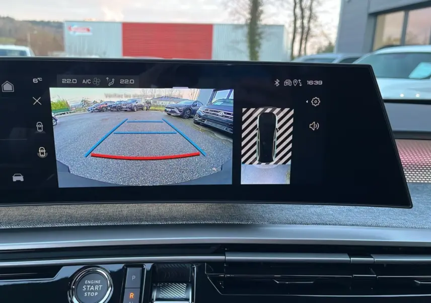 Écran multimédia montrant la caméra de recul du Peugeot 5008 Hybrid gris titane avec toit noir, vue intérieure avant.