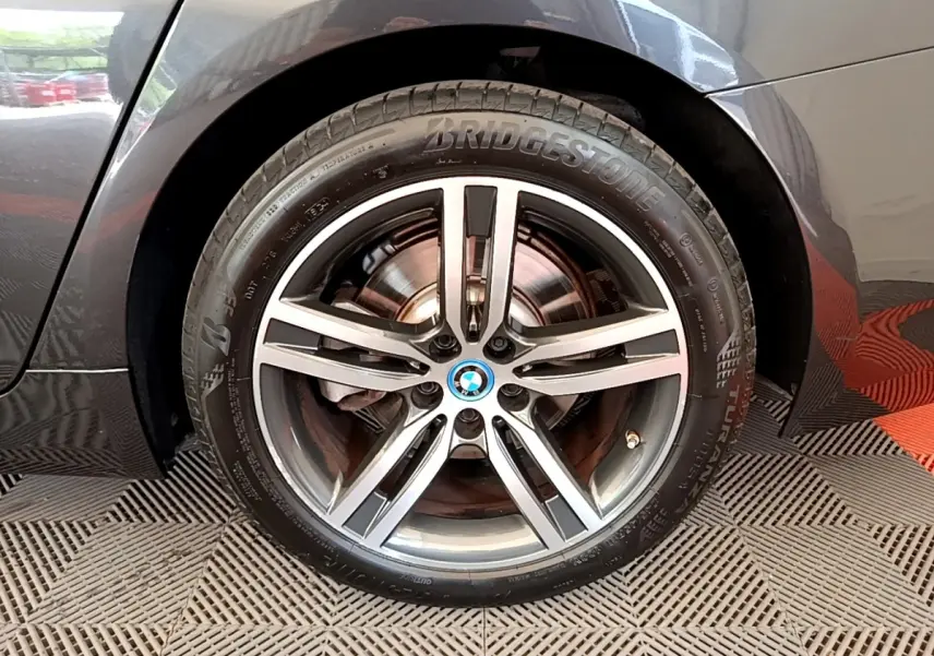 Gros plan sur la roue avant droite gris clair d’une BMW Série 5 Touring 530e avec jante alliage cinq branches.