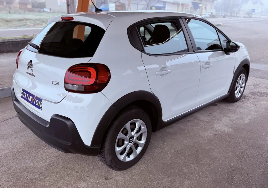 Vue 3/4 arrière droite d'une Citroën C3 Société blanche de 2019 avec feux arrière distinctifs et jantes alliage.