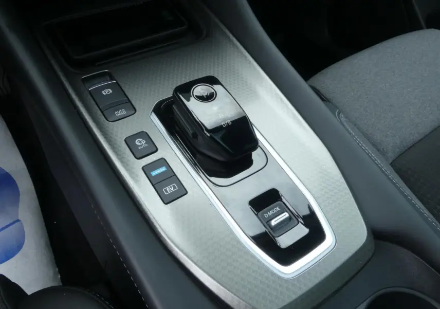 Vue rapprochée de la console centrale du Nissan Qashqai 1.5 e-Power, avec levier de vitesse et boutons de mode.