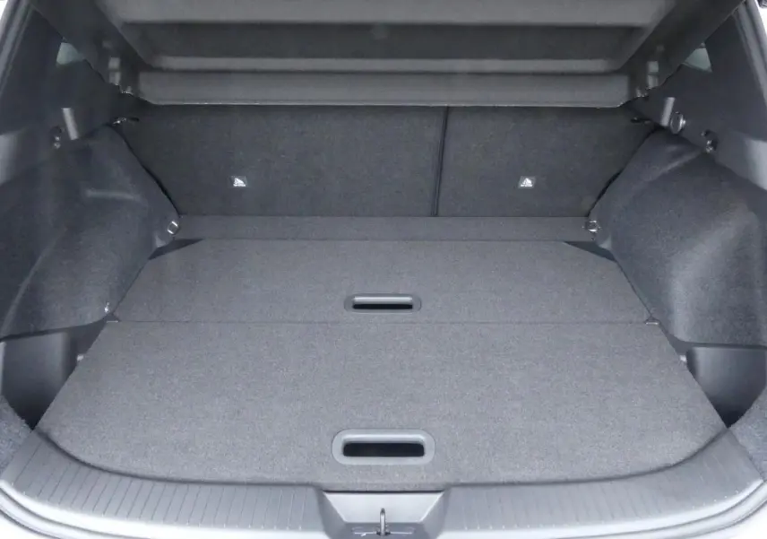 Coffre spacieux du Nissan Qashqai 1.5 e-Power gris métallisé avec plancher modulable et poignées intégrées.