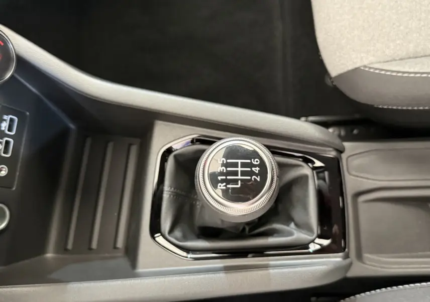 Vue rapprochée du levier de vitesses manuel noir au centre de la console d'une Renault Clio Evolution Blue dCi 100 2025.