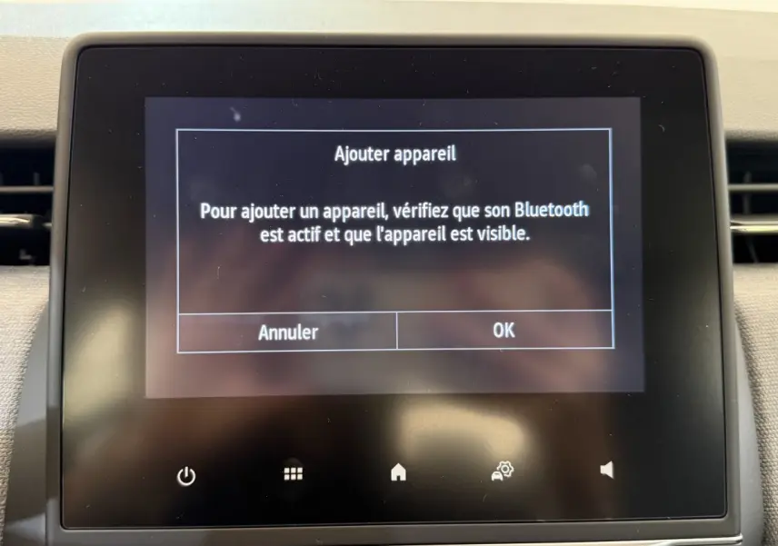 Écran tactile central de la Renault Clio noir affichant la demande d'ajout d'un appareil Bluetooth.