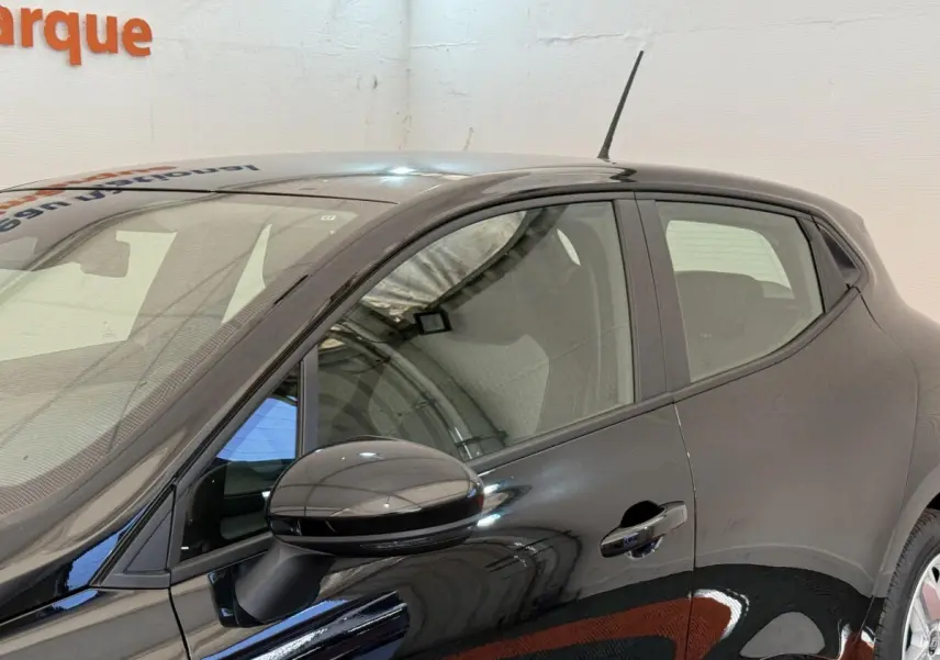 Profil côté gauche de la Renault Clio noire 2025 avec rétroviseur ton caisse et poignée de porte visible.