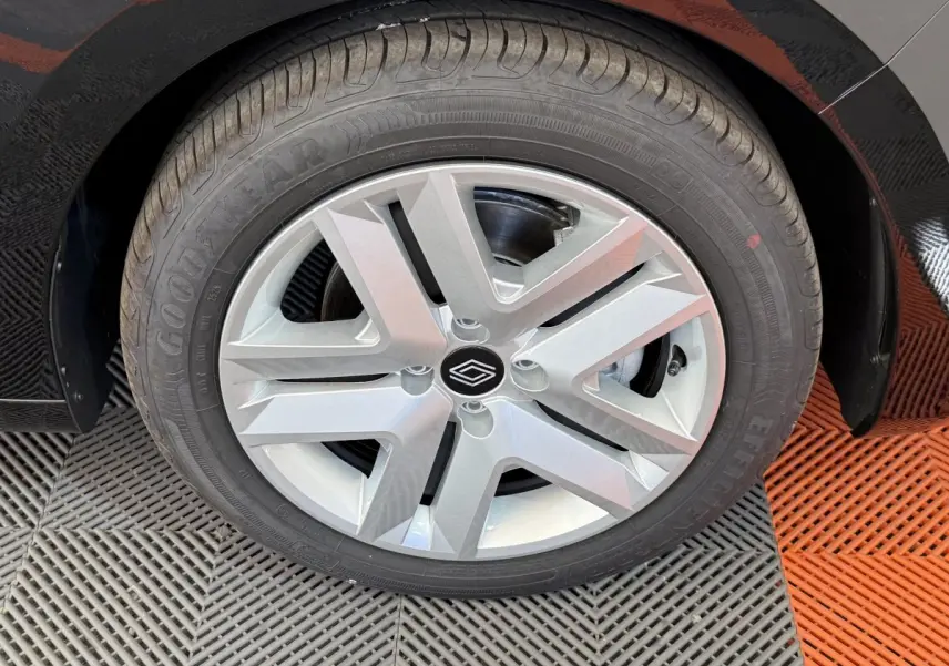 Gros plan sur la roue avant droite noire de la Renault Clio 2025 avec jante argentée au design moderne.