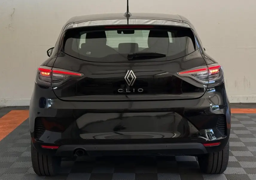 Vue arrière d'une Renault Clio noire 2025 avec feux LED allumés dans un garage intérieur.