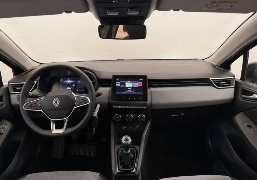 Intérieur de la Renault Clio 2025 en vue frontale, volant cuir noir, écran tactile central et levier de vitesse manuel.