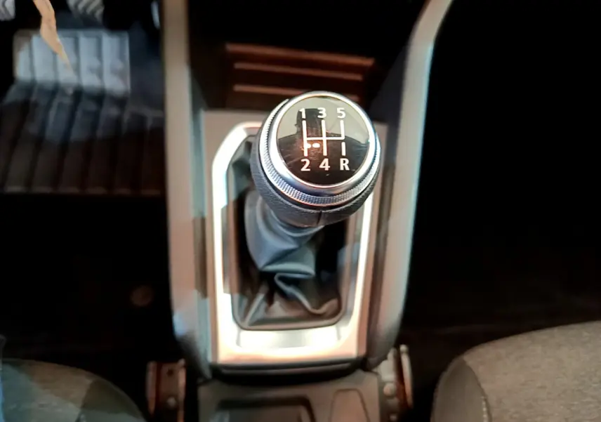 Le levier de vitesse manuel vu de dessus dans l'habitacle sombre d'une Renault Clio Business blanche de 2020.