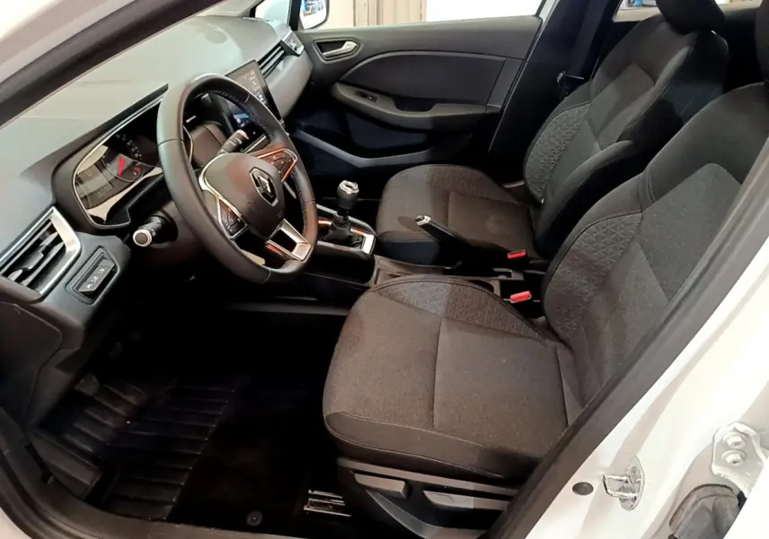Intérieur de la Renault Clio Business TCe 100 2020 en blanc, vue côté conducteur avec volant cuir et sièges tissu gris.
