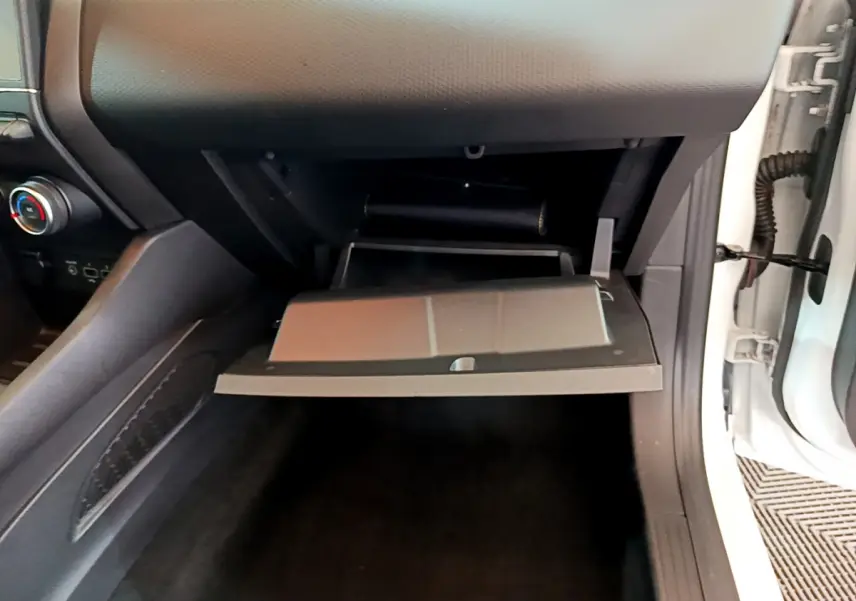 Vue intérieure côté passager de la boîte à gants ouverte dans une Renault Clio Business TCe 100 blanche de 2020.