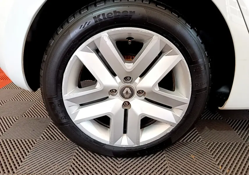 Gros plan sur la roue avant gauche blanche d'une Renault Clio Business TCe 100 avec jante alliage et pneu Kleber.