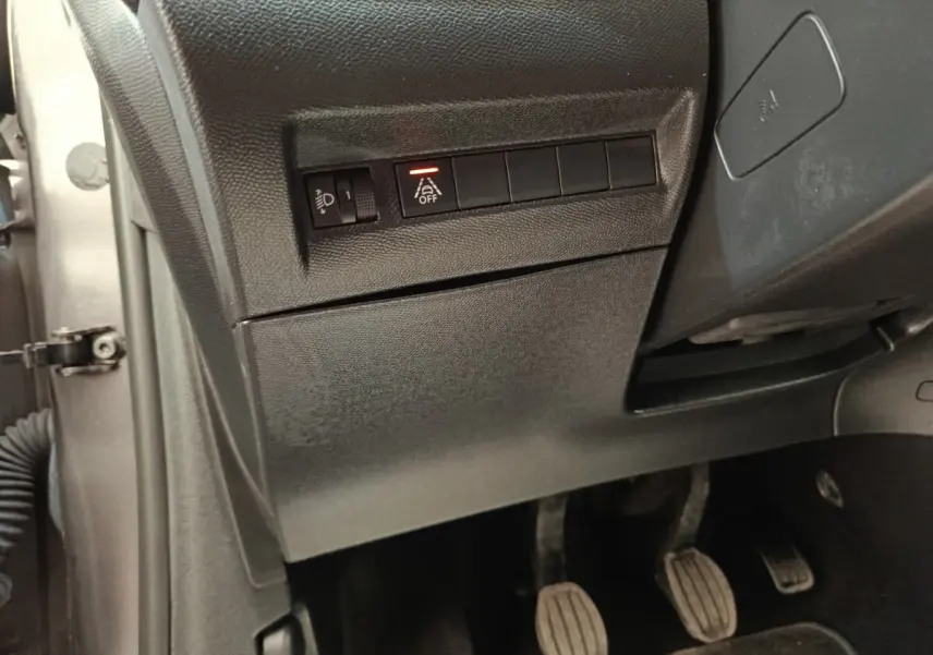 Vue intérieure côté gauche du tableau de bord d'une Peugeot 208 2020 avec commandes d'assistance et pédales visibles.
