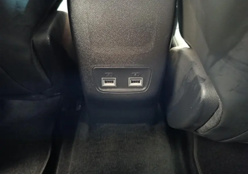 Prise USB double vue en gros plan à l'arrière de la console centrale d'une Peugeot 208 2020 noire.