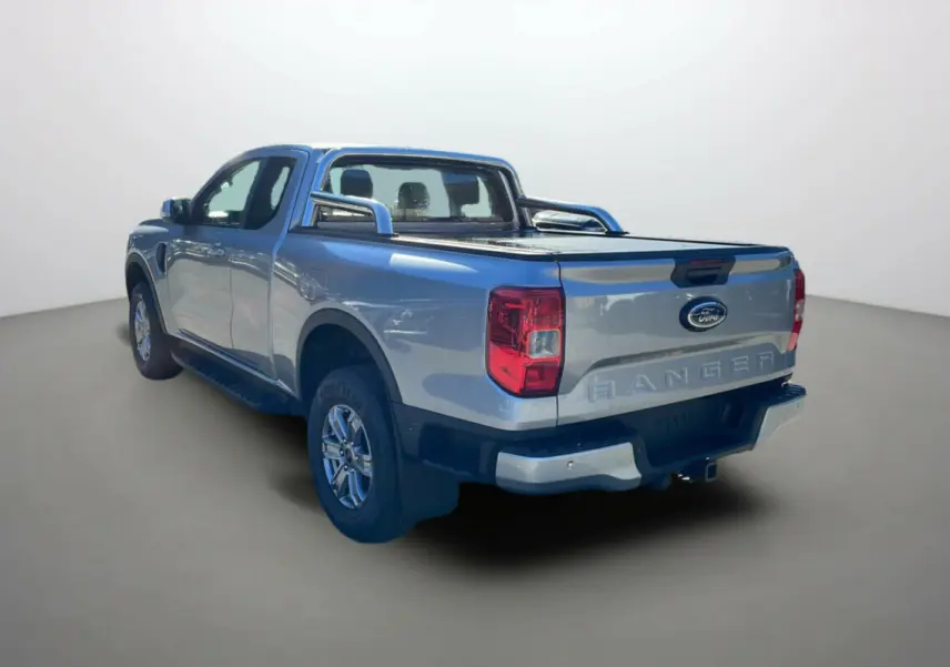Ford Ranger gris iconic vu en 3/4 arrière droit avec arceaux inox et rideau de benne fermé.